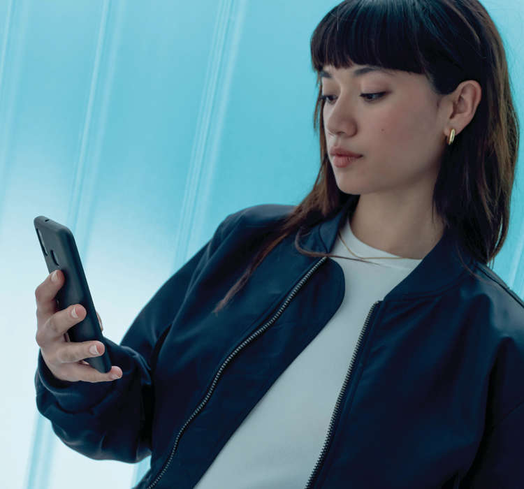 Дівчина дивиться на екран смартфону